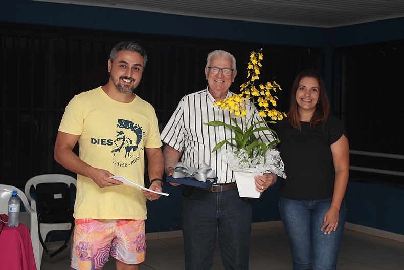 Rangel Gonçalves dos Santos (Conselho Deliberativo) e Adélia Amorim (Diretoria Social), presentearam Sérgio Passarelli com uma flores e uma placa em agradecimento pela palestra (Foto Eduardo Imperador)